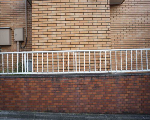 27 a white railing on a brick wall