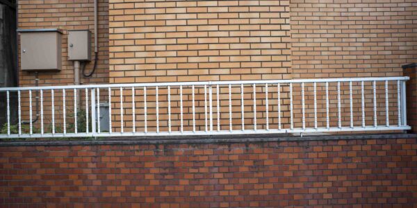 a white railing on a brick wall
